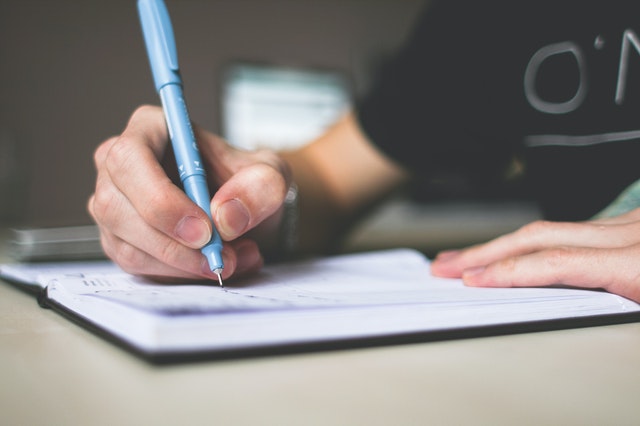 A man's writing a wishlist for buying a house remotely