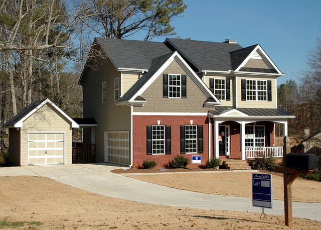 A large two-story house with a detached garage for sale.