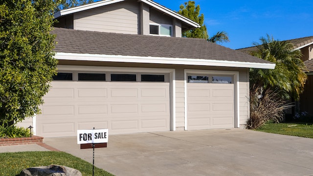 A “For Sale” sign in front of a house.