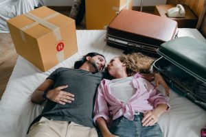 A couple lying on the bed after finding a temporary housing solution.