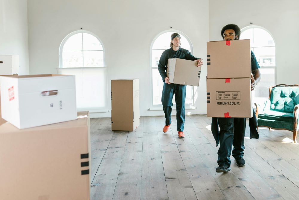Two men carrying heavy boxes